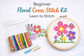 Beginner floral counted cross stitch kit with finished flower design in embroidery hoop, Aida fabric, colorful floss, and pattern chart.